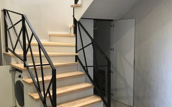 Stairs with a built-in washing machine and a door to the mini-boiler room
