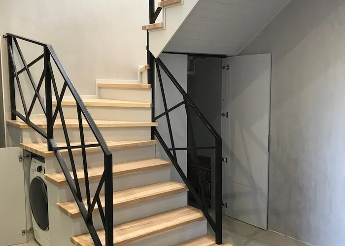 Stairs with a built-in washing machine and a door to the mini-boiler room